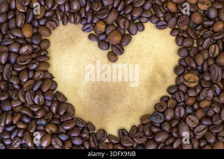 Morning heart. Heart shape made from coffee beans at a vintage paper background Stock Photo