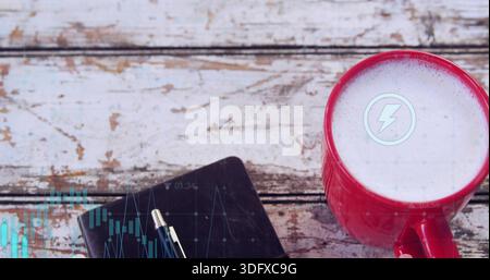 Showing red mug with frothy drink and lightning icon at worn desk, notebook, pens, copy space Stock Photo