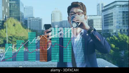 Holding smartphone, sipping coffee, mature exec wearing navy blazer, glasses on railing with charts Stock Photo