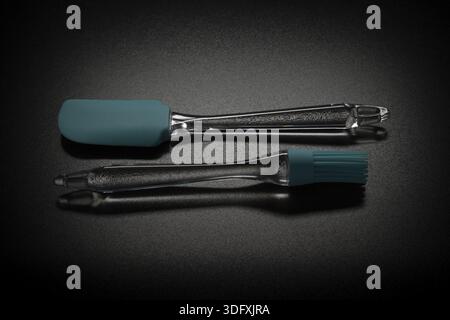 Modern color spatula and brush on black table Stock Photo
