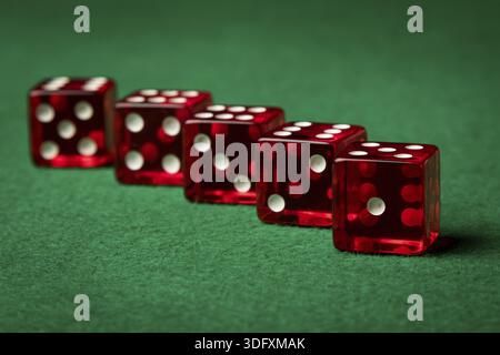 Five red casino dices on a green table Stock Photo
