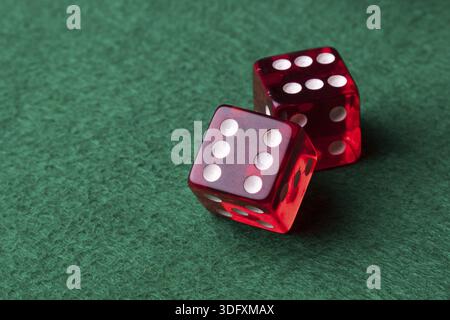 Two red casino dices on green table Stock Photo