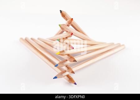 Creatively stacked pencils of different colors on white Stock Photo