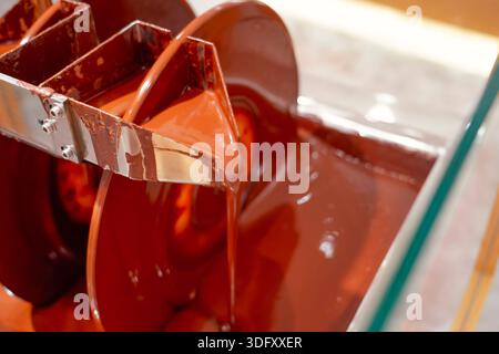 Chocolate machine. Industrial stirring of chocolate. Machines in chocolate factory stir the chocolate mixture in stainless steel containers Stock Photo