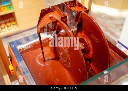 Chocolate machine. Industrial stirring of chocolate. Machines in chocolate factory stir the chocolate mixture in stainless steel containers Stock Photo