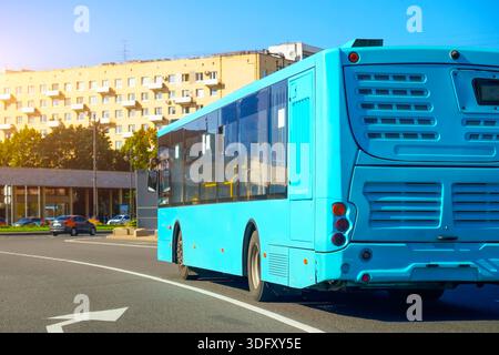 Blue bus turn rear view on the road in along the city street on the route Stock Photo
