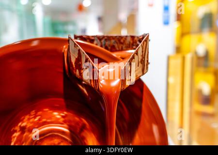 Industrial stirring of chocolate. Chocolate machine in chocolate factory stir the chocolate mixture in stainless steel containers Stock Photo