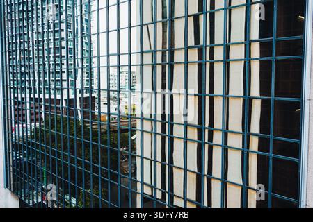 Facade glass window with grid pattern on office building in Bangkok downtown Stock Photo