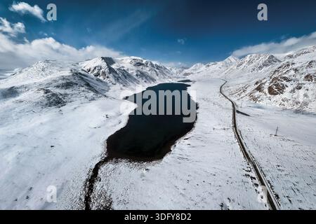 Aerial view of snow covered Arabel Plateau with frozen alpine lake and vast winter wilderness in Kyrgyzstan Stock Photo