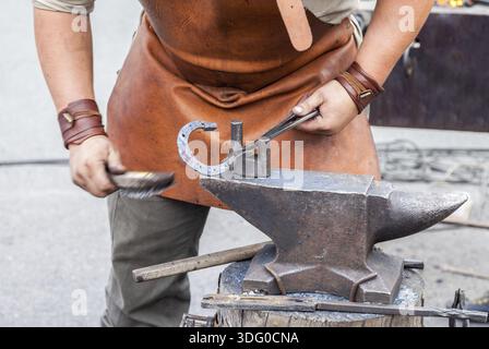 Blacksmith handles the horseshoe on the anvil Stock Photo