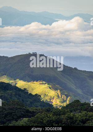 View west from Monteverde resort at sunrise over the hills towards Pacific ocean in vertical format Stock Photo