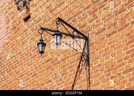 Vintage decorative lantern hanging on an old brick wall Stock Photo