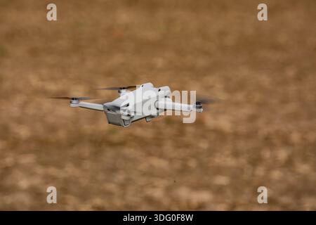 A camera drone or multicopter flying exempted over a field Stock Photo