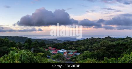 View west from Monteverde resort at sunrise over the hills towards Pacific ocean in broad panoramic format Stock Photo