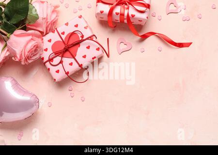 Gift boxes with air balloon, decorative hearts and rose flowers on beige background. Valentines Day celebration Stock Photo