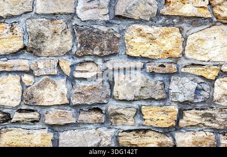 Weathered grey stone wall as creative background texture Stock Photo