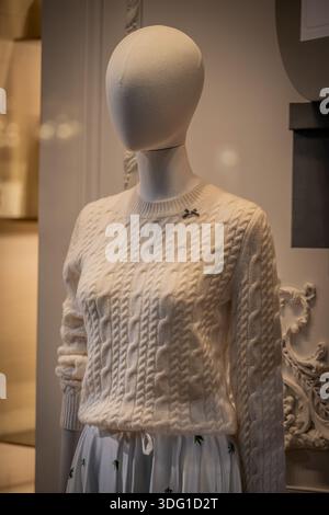 Milan, Italy - 2026, 13 Jan: Elegant Dior FW25 cream cable knit sweater on mannequin, showcasing luxury texture and refined winter style in a chic bou Stock Photo