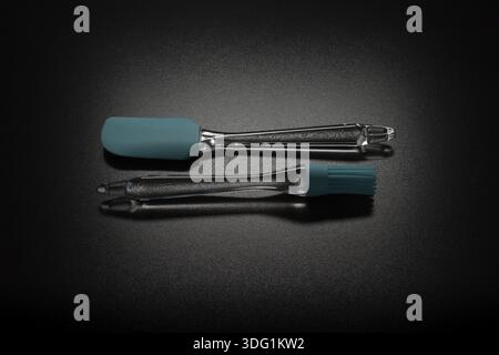 Modern color spatula and brush on black table Stock Photo