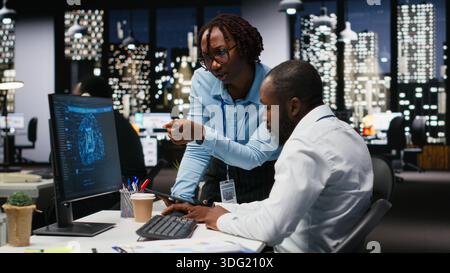 Black IT consultants workers use AI big data and predictive analytics, smart work solutions and cloud computing for adaptive strategies. Artificial intelligence engineering algorithms. Stock Photo