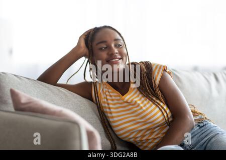 Cheerful young african american lady enjoying weekend at home Stock Photo