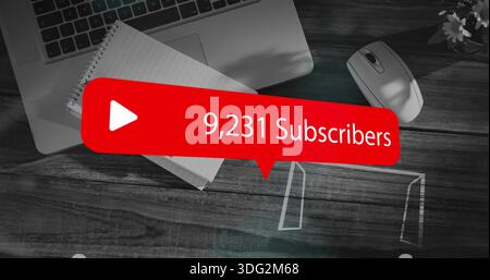 Displaying red subscriber graphic showing 9,231 subscribers over home desk with laptop and notebook Stock Photo
