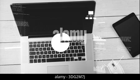 Showing laptop with keys, trackpad, running code on screen at wood desk, tablet, mouse, charts Stock Photo