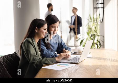 Two positive diverse female colleagues working together Stock Photo