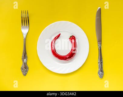 Red spicy chili peppers isolated on yellow background Stock Photo