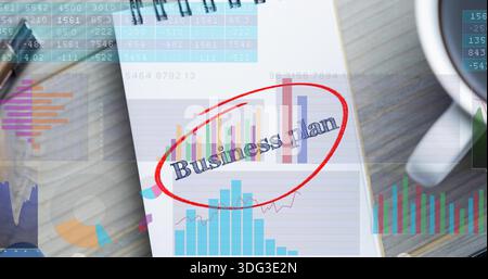 Displaying spiral-bound notepad showing Business plan red-circled with printed charts on wood desk Stock Photo
