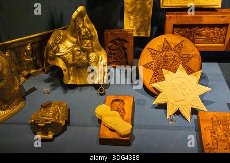 Collection of vintage wooden and metal baking molds displayed in a museum setting. Stock Photo