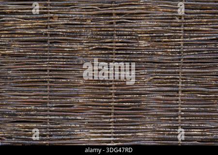 Wicker fence made of thin wooden rods. Natural wooden background. Stock Photo