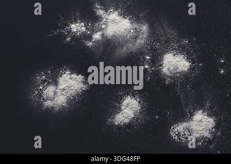 Sprinkled wheat flour splash spots on black background Stock Photo
