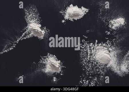 Sprinkled wheat flour splash spots on black background Stock Photo