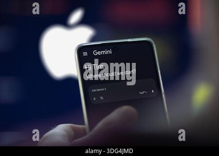 Gemini application on a phone, in the blurred background the logo of Apple. Stock Photo