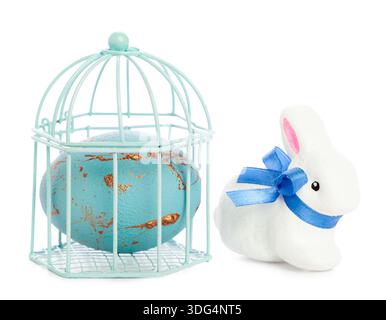 Decorative cage with blue egg and white rabbit figure for spring celebration Stock Photo