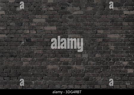 Black wall of black bricks - gloomy room. Industrial building background. Stock Photo