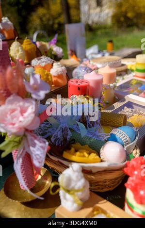 Market stall display with handmade Easter candles and floral arrangements. Concept of festive spring markets, artisanal gift shopping, and professiona Stock Photo