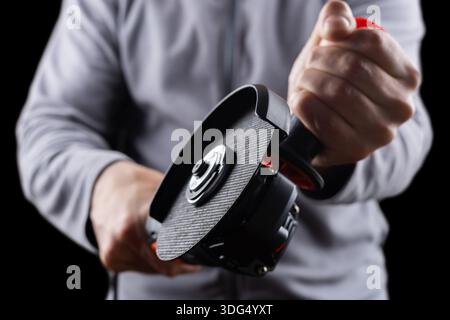 worker hold grinder tool on dark background. Stock Photo