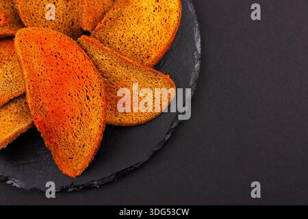 Rye bread crackers in spices on dark background, Beer snack, Stock Photo