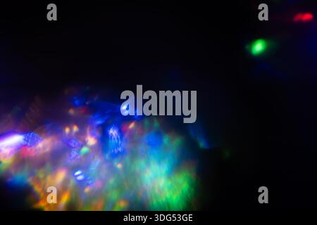 A Prism Rainbow Light on dark Background Overlay. Crystal flare abstract effect. Holographic sunlight reflection wallpaper, colorful glare bokeh. Stock Photo