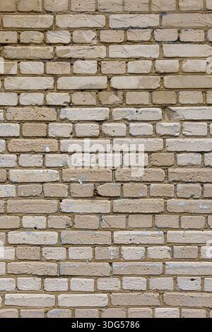 A boring wall of gray silicate bricks. Neutral building background of degradation. Stock Photo