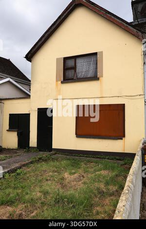 Vacant boarded up house in Limerick, Ireland. Abandoned home with doors and windows secured with steel plates against theft and vandalism. Stock Photo