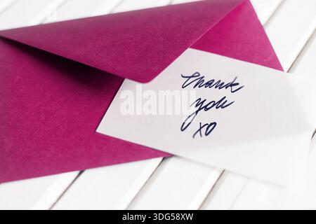 Handwritten thank you note in fushia pink envelope Stock Photo