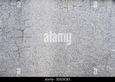 Close-up of a weathered gray concrete wall with rough texture and cracks suitable as an abstract architectural background Stock Photo