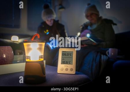 Symbolic image of a blackout, widespread, prolonged power failure, in a private setting, thermometer showing low room temperature, outside temperature Stock Photo