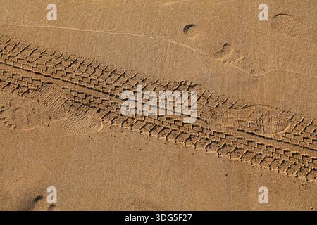 Car tire tracks on beach sand in Morocco. Imprinted tire traces. Stock Photo