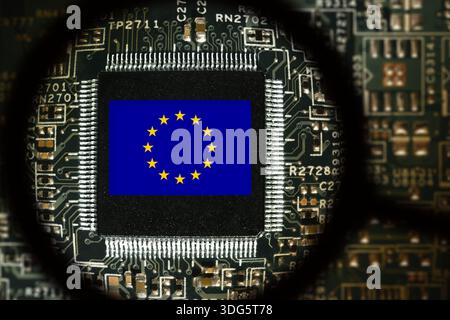 Flag of EU on a processor. Computer board with chip. View through magnifying glass Stock Photo