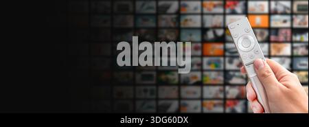 Multimedia video streaming concept. Television set, remote control in hand Stock Photo
