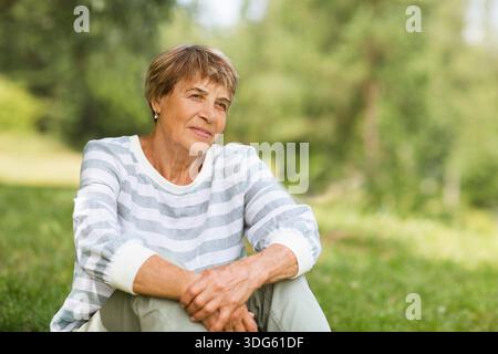 senior woman relaxed outdoors. copy space. Slow life. Enjoying the little things. spends time in nature in summer. international day of older people || Model released Stock Photo