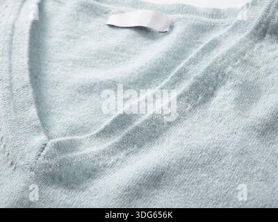 Light gray V-neck sweater close-up with visible texture and fabric details Stock Photo